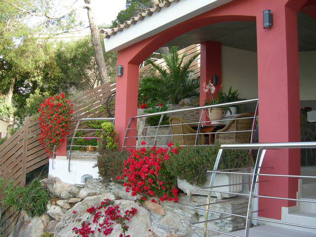 L'entrée de la villa, murs rouges et fleurs